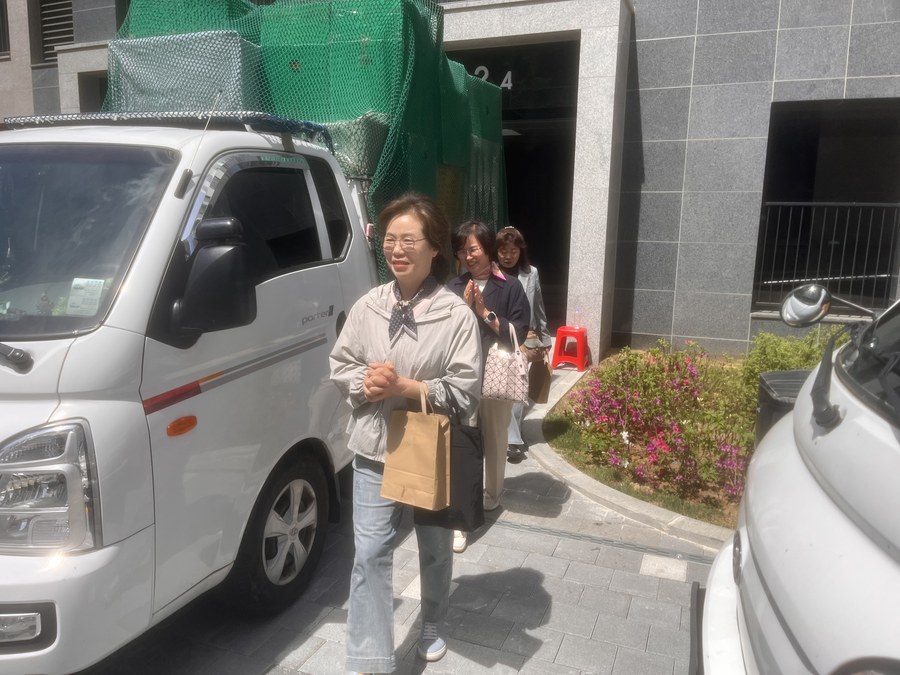 햇살 아래 종이가방을 들고 거리로 나서는 전도팀